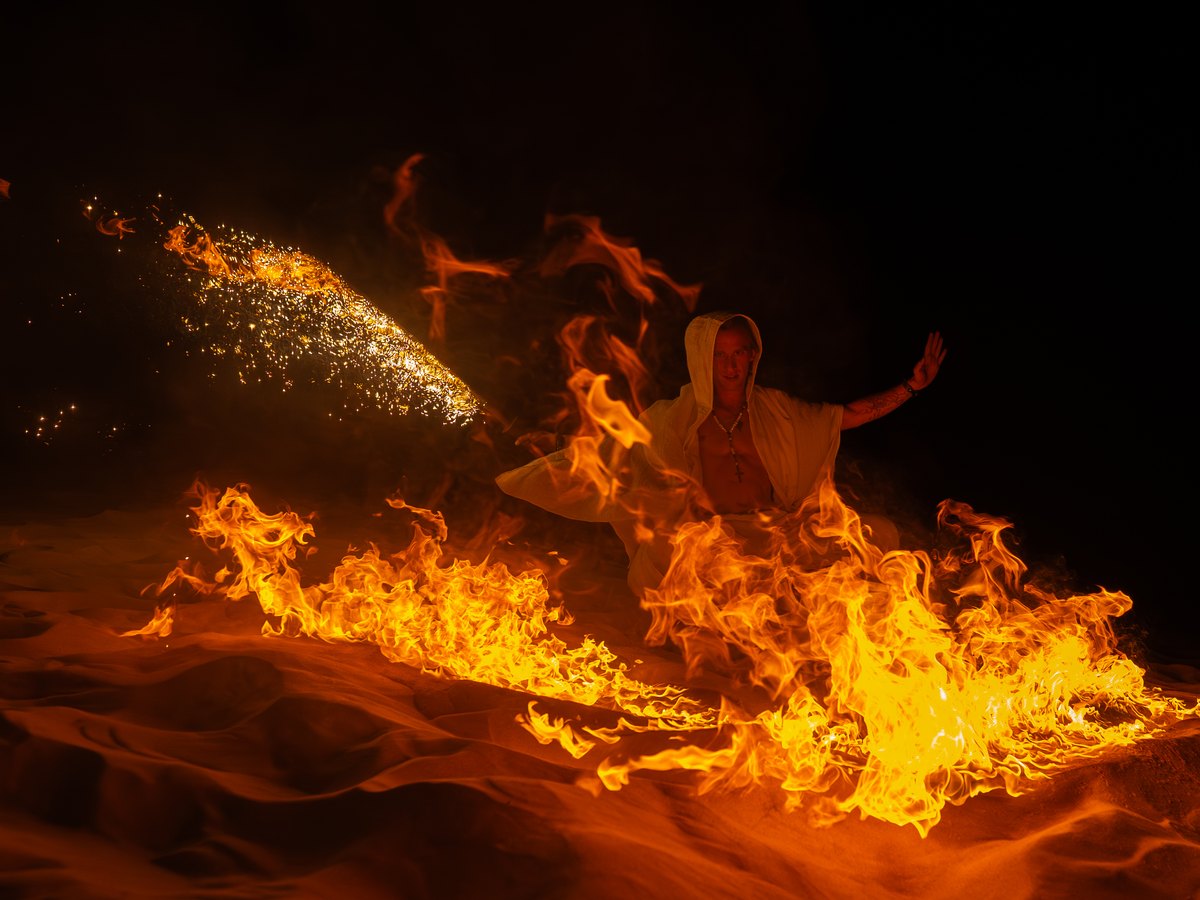 Garrett Brown in a curtain of fire on a sand dune at night